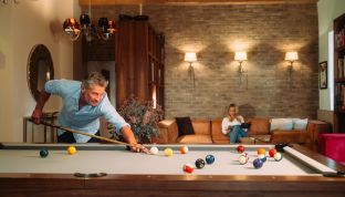 Billard Lounge im Boutique Hotel Cortisen am Wolfgangsee Mann spielt Billard in der Lounge im Boutique Hotel am Wolfgangsee