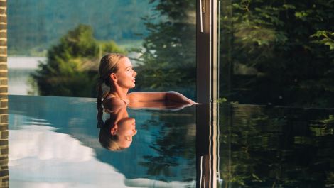 Wellnesshotel für Erwachsene mit Pool im Salzburger Land Frau entspannt im Pool des Wellnesshotels für Erwachsene im Salzburger Land